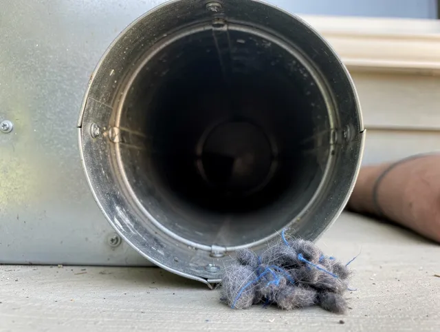 Trumbull Dryer Vent Cleaning technician using specialized equipment to clear severe dryer vent blockage in Trumbull